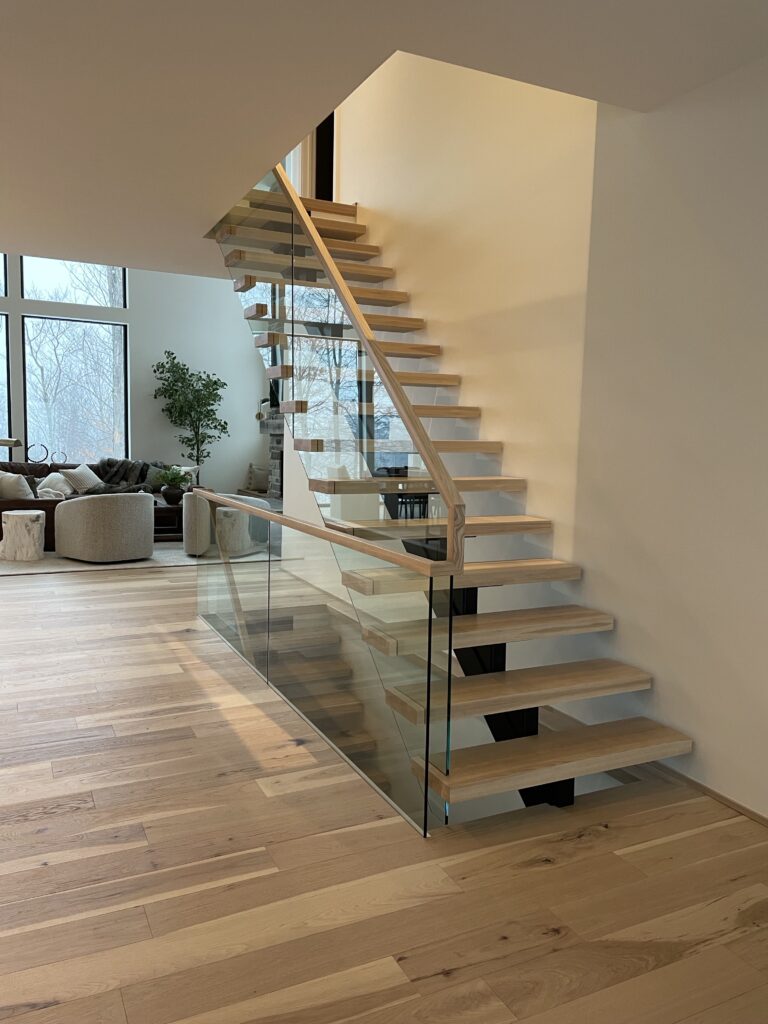 cage-escalier-rampe-verre-trempe-frene-finition-vernis-minimaliste Escalier autoportant à limon central en acier avec marches en frene et garde-corps en verre au style sur-mesure – Escaliers G Alary