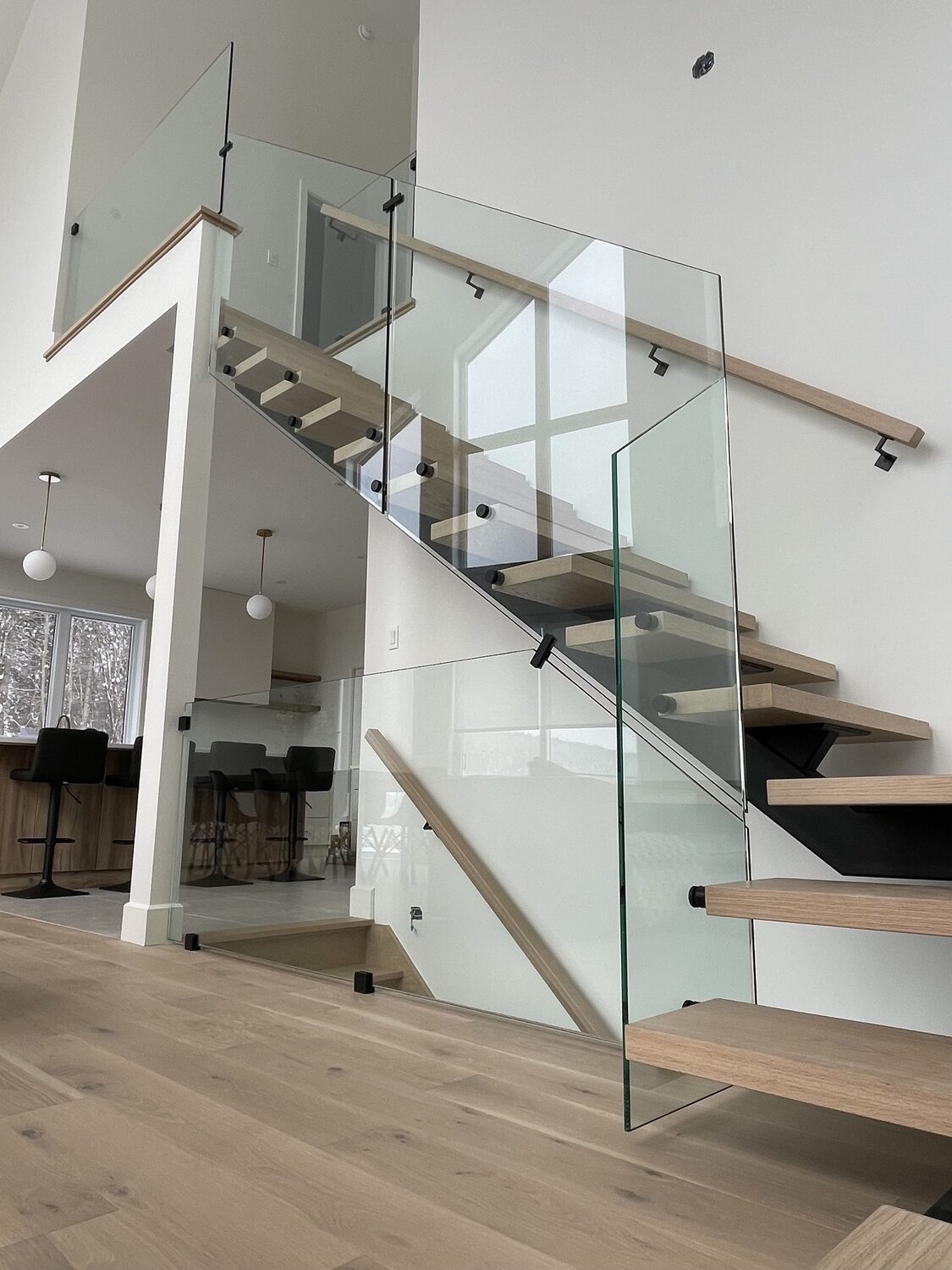 escalier-flottant-garde-corps-verre-erable-bois-naturel-modern-saint-sauveur (1) Escalier sur mesure moderne avec marches flottantes en bois et garde-corps en verre. Design épuré, lumineux et sécuritaire pour une maison contemporaine au Québec.